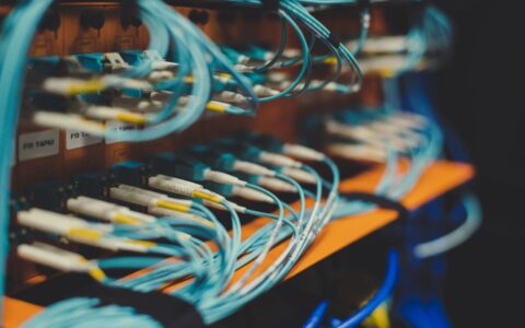 network fiber cables plugged in modern switch on blurred background